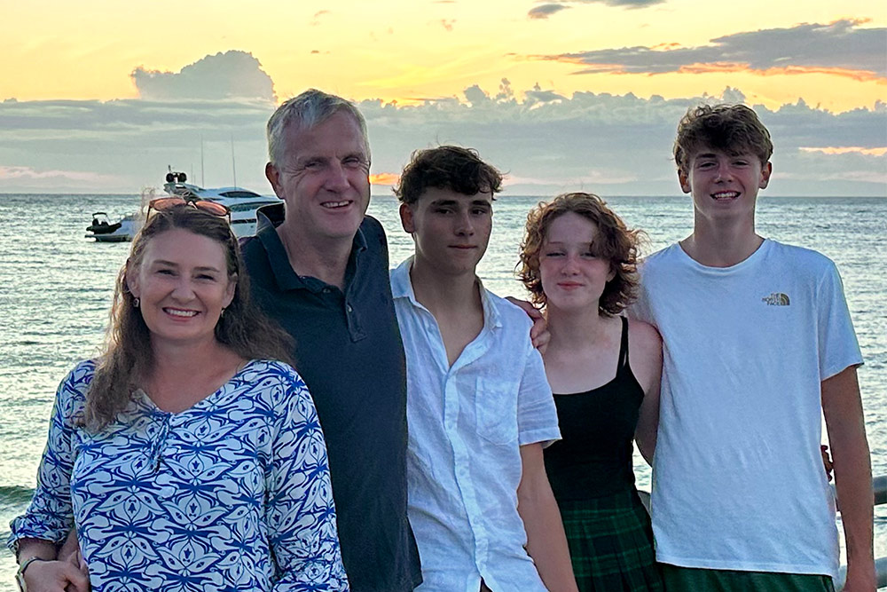 Michelle and her family standing in front of a sunset