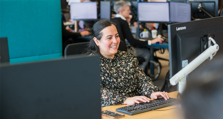 Woman typing at a computer in an office.