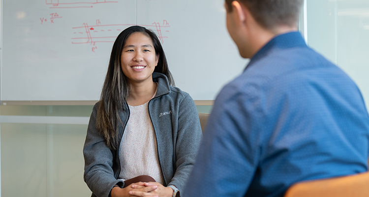 Two people talking, the woman is in focus.