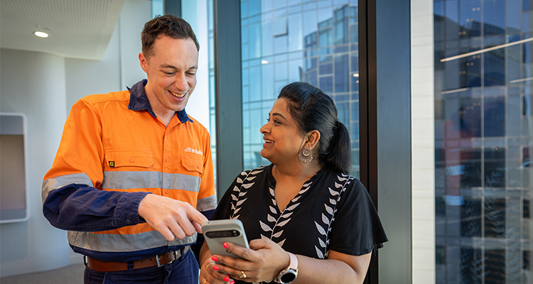 Two people talking, the man is in high-vis clothing.